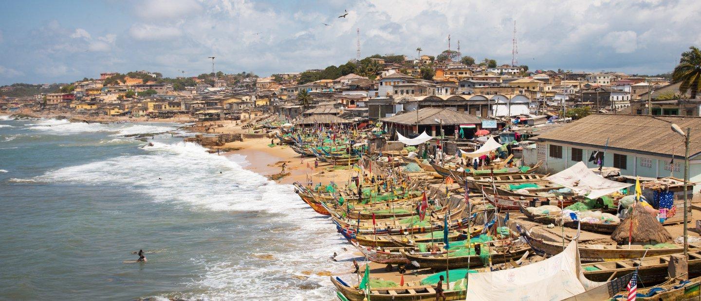 这是加纳一个水上小镇的航拍照片，海滩上排列着船只.