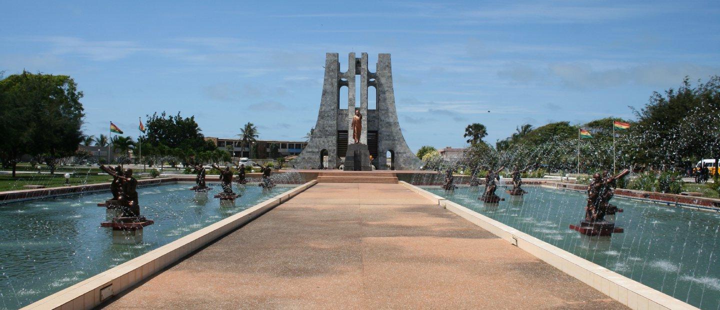 加纳的一个喷泉，中间有雕塑和一条小路.