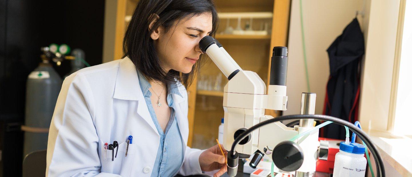 一位妇女在实验室里观察显微镜.